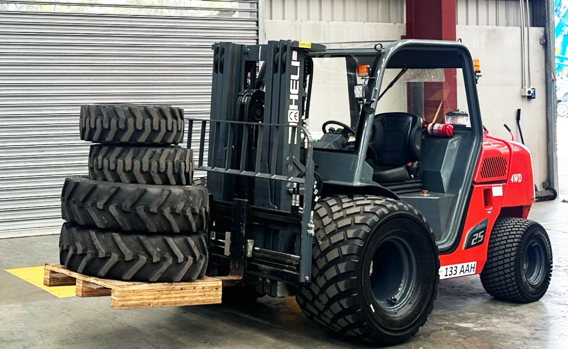All-terrain forklift carrying a load of heavy tires for maintenance