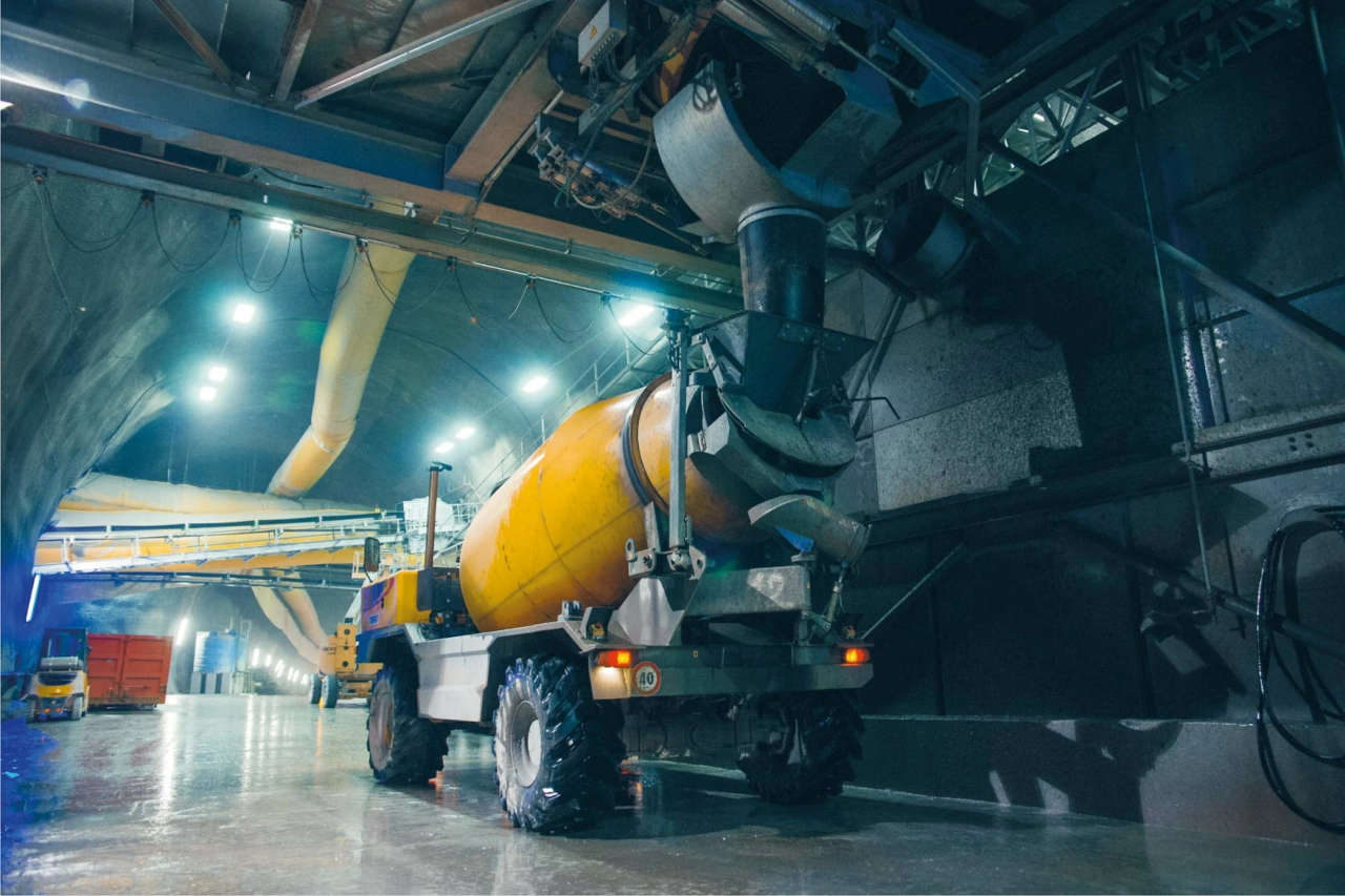 4x4 mixer truck loading up with concrete in an underground tunnel